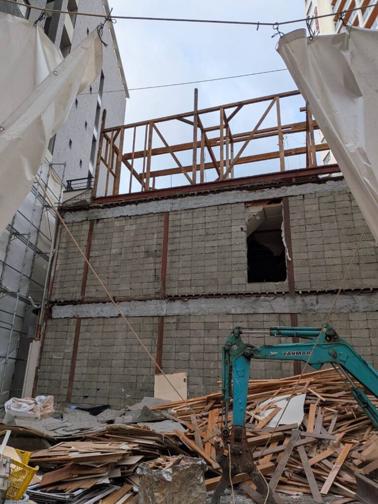③ 上屋解体写真
福岡市中央区高砂1丁目の建物解体工事。上部構造の解体が進み、木造躯体とコンクリートブロック壁が露出した状態。