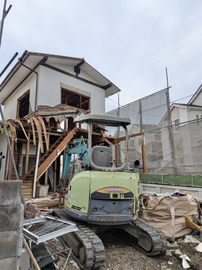 福岡市早良区田隈1丁目で木造住宅を重機で解体している施工中の様子。